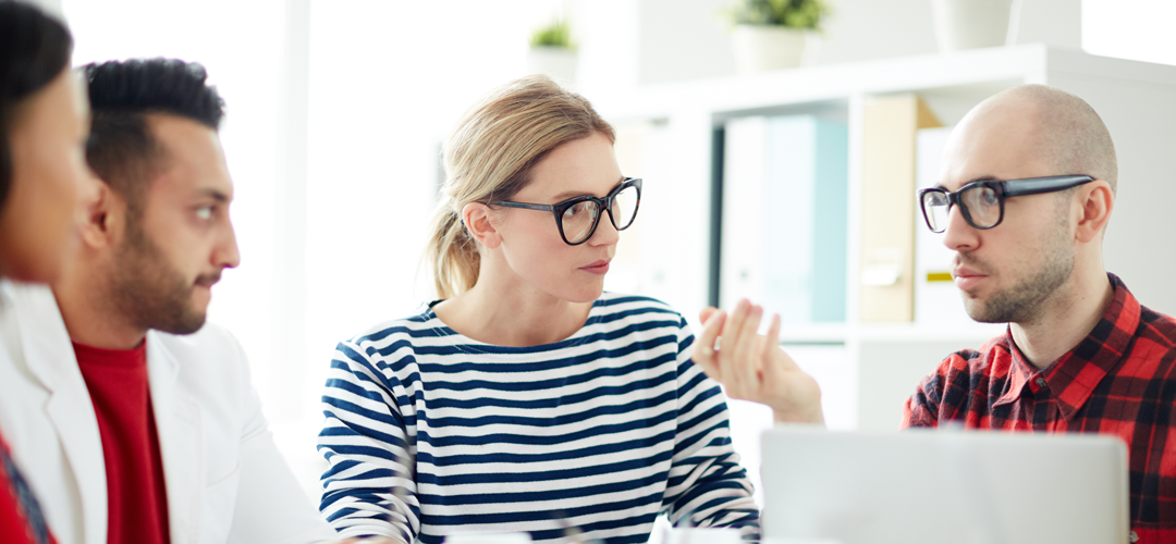 Responsable RH avec lunettes en réunion évaluant des prestataires pour choisir son CSE externalisé