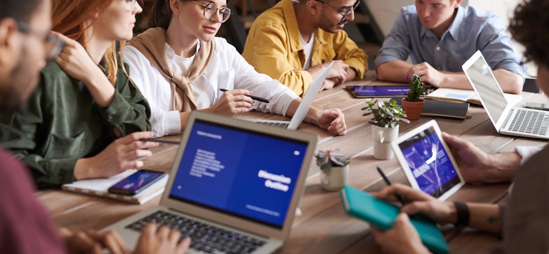 Prime de partage de la valeur en PME — équipe en réunion Dirigeant de PME présentant la prime de partage de la valeur à son équipe en réunion